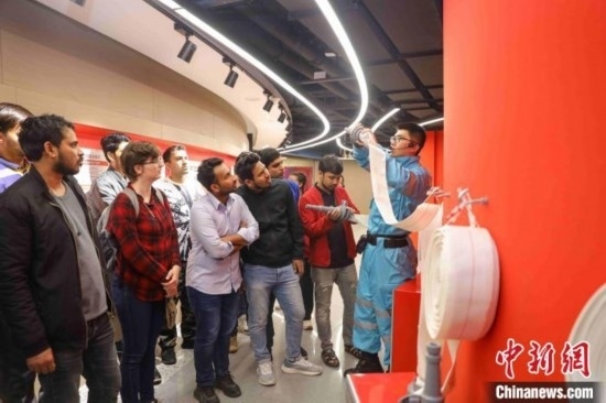 5月9日，工作人員指導(dǎo)留學(xué)生正確使用消防水帶。張鷹 攝