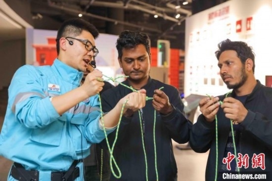 5月9日，工作人員指導(dǎo)留學(xué)生學(xué)習(xí)打繩結(jié)。張鷹 攝