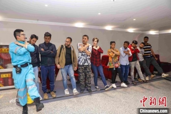 5月9日，工作人員指導(dǎo)留學(xué)生練習(xí)逃生技巧。張鷹 攝