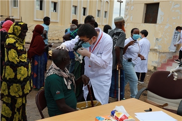 在義診現(xiàn)場，中國醫(yī)生與當(dāng)?shù)鼐用窈嫌傲裟?，吉布提鹽業(yè)投資公司供圖
