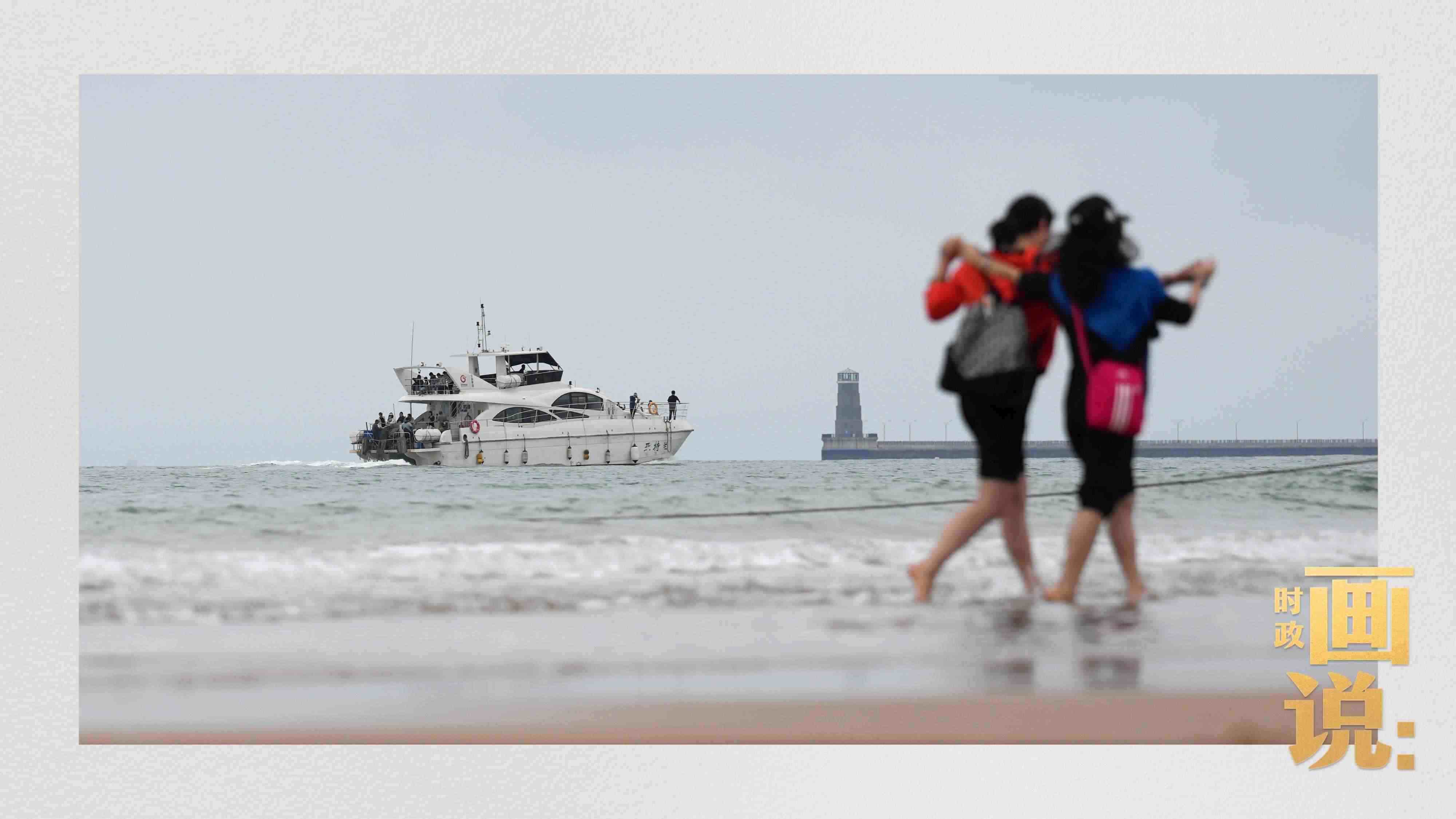 △日照陽光海岸綠道上的萬平口景區(qū)，一對(duì)游客在海浪中翩然起舞。