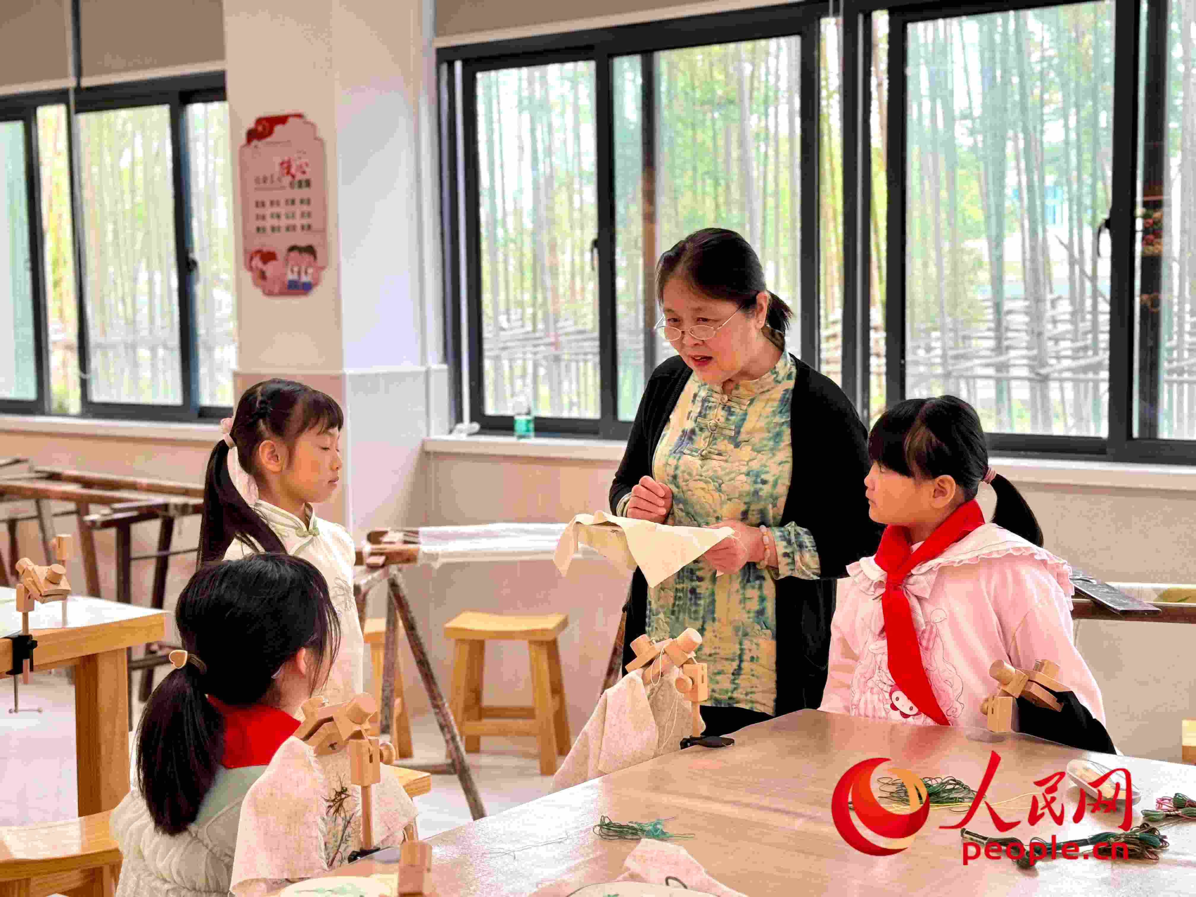 顧建珍（左三）在教孩子們刺繡知識(shí)。人民網(wǎng) 周靜圓攝