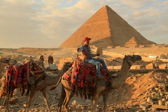 1月24日，商販騎駱駝離開埃及吉薩金字塔景區(qū)。新華社記者 隋先凱 攝