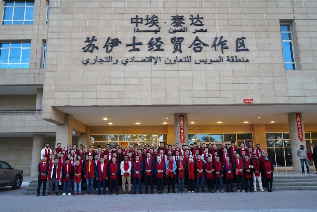 2024年2月11日，在位于埃及蘇伊士省的中?！ぬ┻_(dá)蘇伊士經(jīng)貿(mào)合作區(qū)，中埃員工在合作區(qū)辦公大樓前合影拜年。新華社發(fā)（泰達(dá)合作區(qū)供圖）