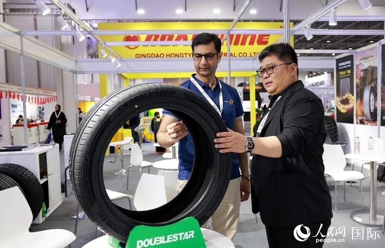 工作人員向客戶展示雙星電動汽車輪胎。和傳統(tǒng)汽車輪胎相比，電動汽車輪胎具有更高承載能力、更加靜音舒適、更好極速抓地、更低滾動阻力等特點。人民網(wǎng)記者 管克江攝