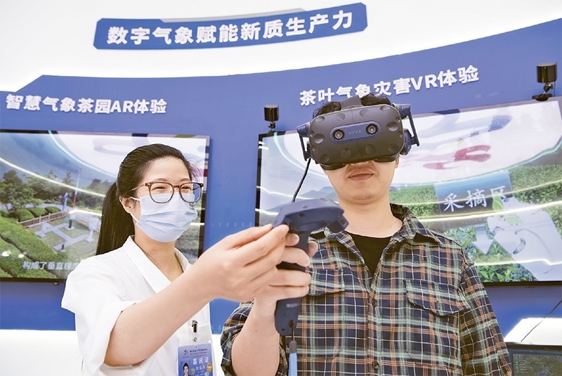 2024年5月23日，第七屆數(shù)字中國(guó)建設(shè)峰會(huì)現(xiàn)場(chǎng)體驗(yàn)區(qū)在福州海峽國(guó)際會(huì)展中心向?qū)I(yè)觀眾開放。本次現(xiàn)場(chǎng)體驗(yàn)區(qū)圍繞本屆峰會(huì)主題“釋放數(shù)據(jù)要素價(jià)值，發(fā)展新質(zhì)生產(chǎn)力”，設(shè)置“數(shù)字惠民”、“數(shù)字能力”、“數(shù)字基礎(chǔ)”、“數(shù)字生態(tài)”、“數(shù)字賦能”五大板塊。圖為一名觀眾（右）在數(shù)字氣象賦能新質(zhì)生產(chǎn)力展臺(tái)上進(jìn)行體驗(yàn)。 新華社記者 魏培全/攝