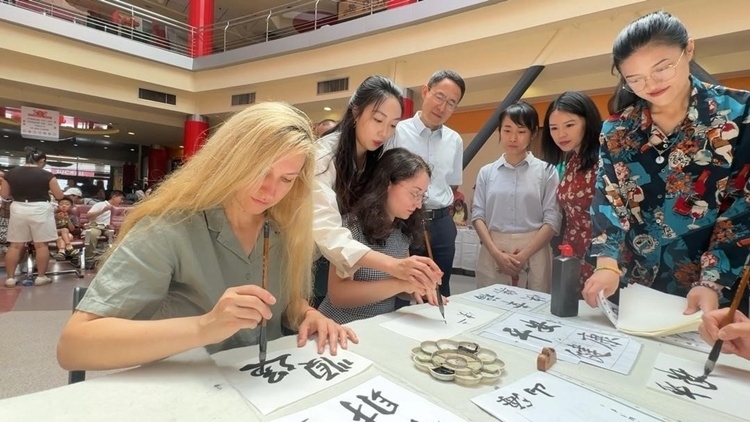 羅馬尼亞友人在活動現(xiàn)場學寫漢字。中國駐羅馬尼亞大使館領(lǐng)僑處供圖