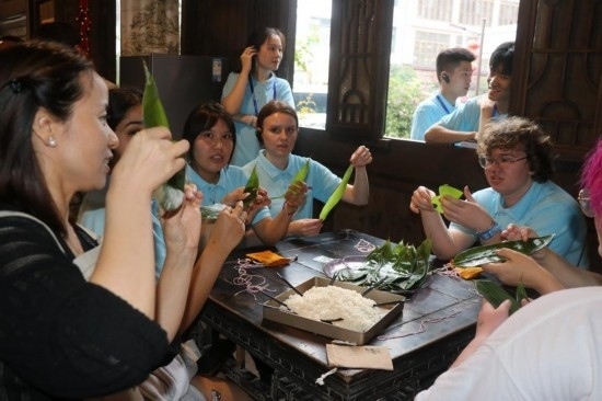 6月9日，美國青年代表在重慶永川松溉古鎮(zhèn)體驗包粽子。新華社記者 周思宇 攝