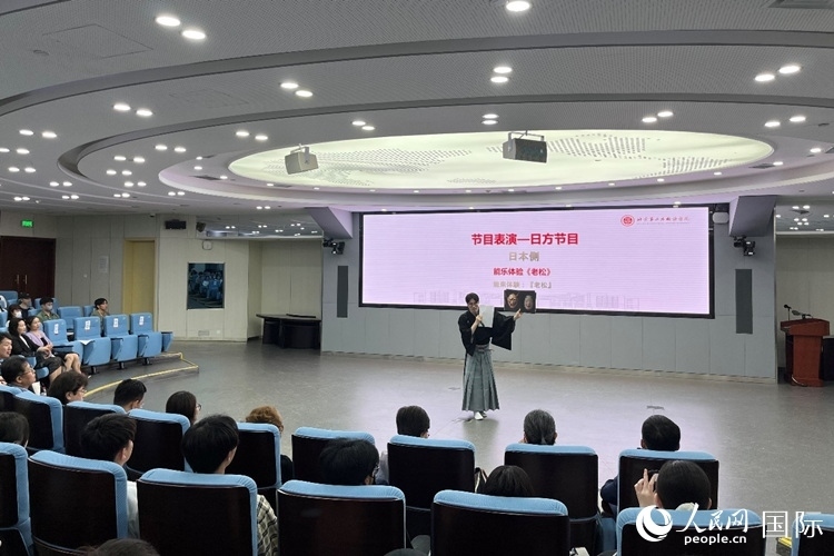 日本大學(xué)生介紹能樂知識。人民網(wǎng)記者 陳思攝