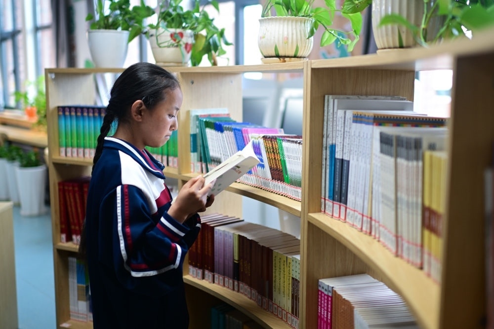 6月18日，果洛西寧民族中學(xué)學(xué)生尼東拉毛在圖書室看書。