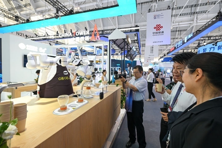 6月20日，與會者品嘗機(jī)器人沖調(diào)出的咖啡。新華社記者 孫凡越 攝