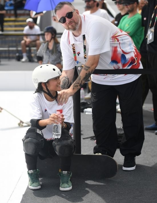 6月20日，鄭好好（左）在比賽間隙與教練互動，她在預(yù)賽中最佳成績?yōu)?2.60分。當(dāng)日，巴黎奧運會資格系列賽布達(dá)佩斯站滑板女子碗池預(yù)賽在布達(dá)佩斯舉行。新華社記者 賀燦鈴 攝