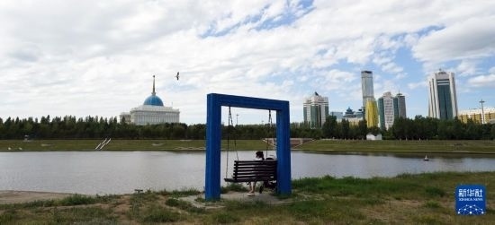 6月30日，一名女子在哈薩克斯坦首都阿斯塔納伊希姆河畔休息。新華社記者 王建華 攝