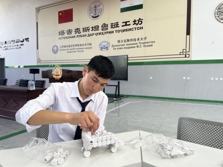 在塔吉克斯坦魯班工坊內(nèi)，學員正在操作能力源創(chuàng)新套件。本報記者 屈佩 攝