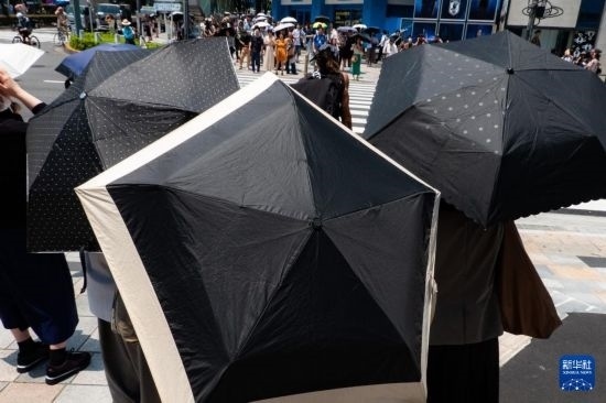 7月4日，人們?cè)谌毡緰|京原宿的街道上等待紅綠燈。新華社記者 張笑宇 攝