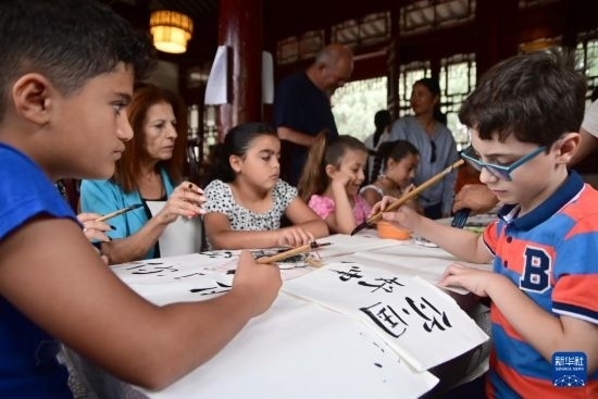 7月4日，在馬耳他桑塔露琪亞市的中國古典園林“靜園”，人們體驗中國書法。新華社發(fā)（喬納森·博格 攝）