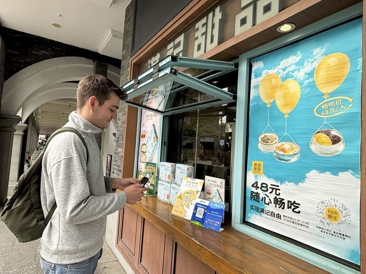 來自德國(guó)的留學(xué)生理查德在杭州西湖邊一家商鋪使用支付寶掃碼支付（2024年4月11日攝）。新華社發(fā)
