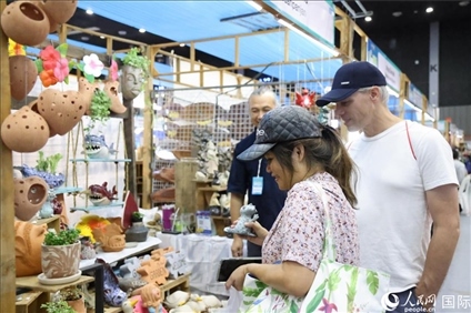 游客在蘭納博覽會特色展位上選購工藝品。人民網(wǎng)記者楊一攝