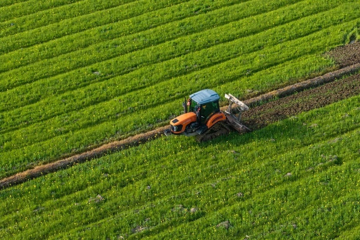 2024年3月19日，在湖南省常德市鼎城區(qū)謝家鋪鎮(zhèn)港中坪村，村民駕駛農(nóng)機翻耕田地（無人機照片）。新華社記者 陳思汗 攝