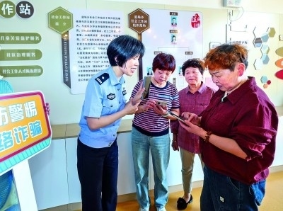 浙江湖州民警指導(dǎo)居民加入湖州“e企安”微信群，實(shí)時(shí)接收反詐信息。新華社發(fā)