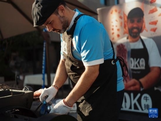 7月19日，在蕪湖古城，馬丁在當(dāng)天舉行的啤酒節(jié)上制作牛排。新華社發(fā)（繆雨晨 攝）