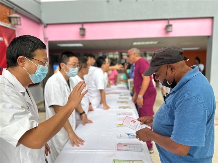 援圭醫(yī)療隊(duì)隊(duì)員們?cè)趩?dòng)儀式上為當(dāng)?shù)孛癖姺职l(fā)宣傳手冊(cè)。中國(guó)援助圭亞那醫(yī)療隊(duì)供圖