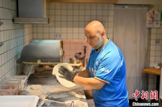 近日，韋榮耀在自家披薩小店內(nèi)忙活。俞靖 攝