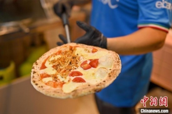 近日，韋榮耀展示他制作的“老友味”披薩。 俞靖 攝
