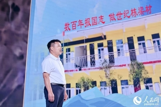 張玉滾分享用一根扁擔(dān)送孩子們走出大山的故事。人民網(wǎng)攝