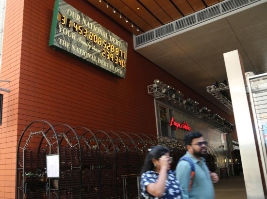 2023年5月29日，人們經(jīng)過(guò)美國(guó)紐約曼哈頓的“國(guó)債鐘”。“國(guó)債鐘”是一個(gè)大型計(jì)數(shù)器，它實(shí)時(shí)更新美國(guó)的公共債務(wù)總額，并顯示出每個(gè)美國(guó)家庭所要負(fù)擔(dān)的數(shù)額。 新華社記者劉亞南攝