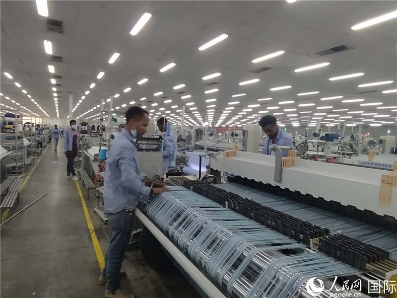 無錫金茂埃塞面料廠車間內(nèi)，當(dāng)?shù)毓と苏谝唤z不茍地作業(yè)。人民網(wǎng)記者 黃培昭攝