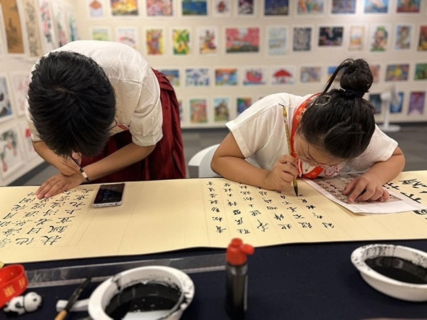 參加本次展覽的青少年在現(xiàn)場進行書法創(chuàng)作。主辦方供圖