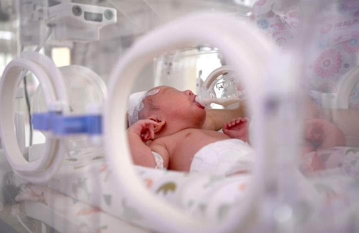 2024年6月1日，在西安國(guó)際醫(yī)學(xué)中心醫(yī)院新生兒科病房，護(hù)士為新生兒喂奶。 新華社記者 劉瀟 攝