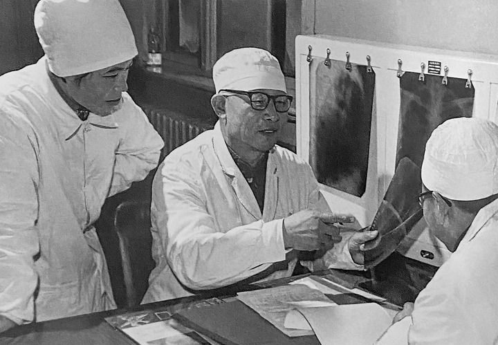1980年1月16日，中日友好醫(yī)院首任院長(zhǎng)辛育齡（中）在內(nèi)蒙古結(jié)核病院與胸外科醫(yī)師討論病例（翻拍照片）。 新華社發(fā)