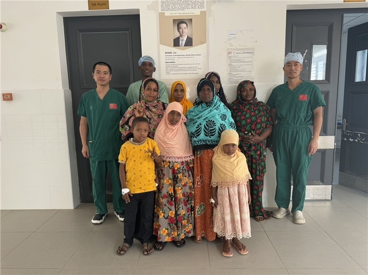 李廣（右一）和王林醫(yī)生與部分患者合影。中國援桑醫(yī)療隊(duì)供圖