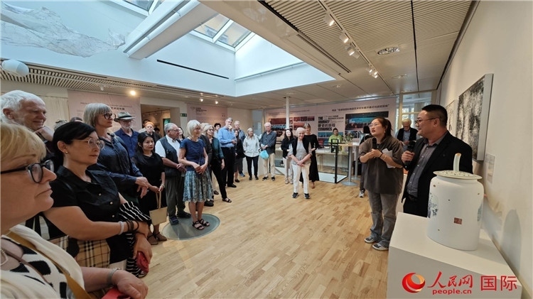 參展人、景德鎮(zhèn)陶瓷大學美術(shù)學院副院長邵長宗（右一）向來賓介紹參展作品。人民網(wǎng)記者 殷淼攝