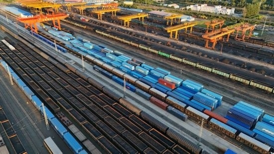 這是2024年8月14日在黑龍江綏芬河鐵路口岸集裝箱換裝場拍攝的集裝箱換裝作業(yè)現(xiàn)場（無人機(jī)照片）。今年前七個(gè)月，綏芬河鐵路口岸開行中歐班列573列，運(yùn)量達(dá)55246標(biāo)箱，同比分別增長23%和18%，班列數(shù)量持續(xù)保持高位運(yùn)行。