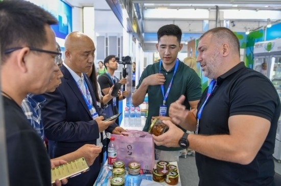2023年8月23日，在第十四屆中國—東北亞博覽會(huì)東北亞商品館，俄羅斯參展商向參觀者介紹商品。