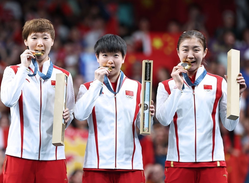 冠軍中國隊選手王曼昱、孫穎莎、陳夢（從左至右）在巴黎奧運(yùn)會乒乓球女子團(tuán)體頒獎儀式上（2024年8月10日攝）。新華社記者 王東震 攝
