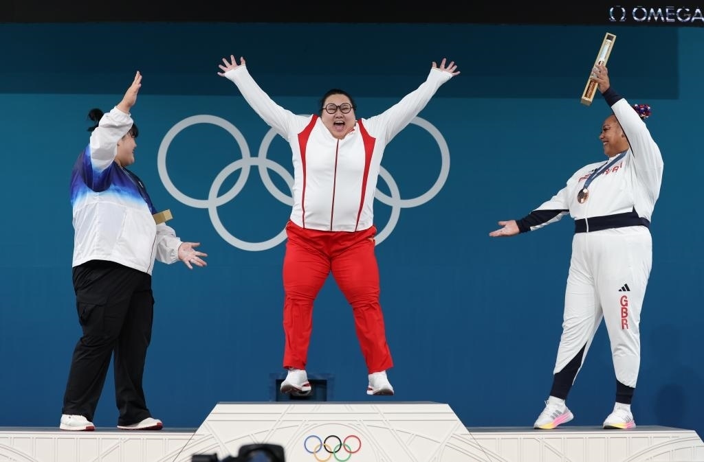 中國選手李雯雯（中）在巴黎奧運(yùn)會舉重女子81公斤以上級頒獎儀式中登上領(lǐng)獎臺（2024年8月11日攝）。新華社記者 楊磊 攝