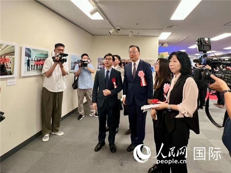 中國國際航空日韓地區(qū)支社支社長馮力為中國駐日本大使館臨時代辦施泳等嘉賓介紹展出圖片。人民網(wǎng) 許可攝