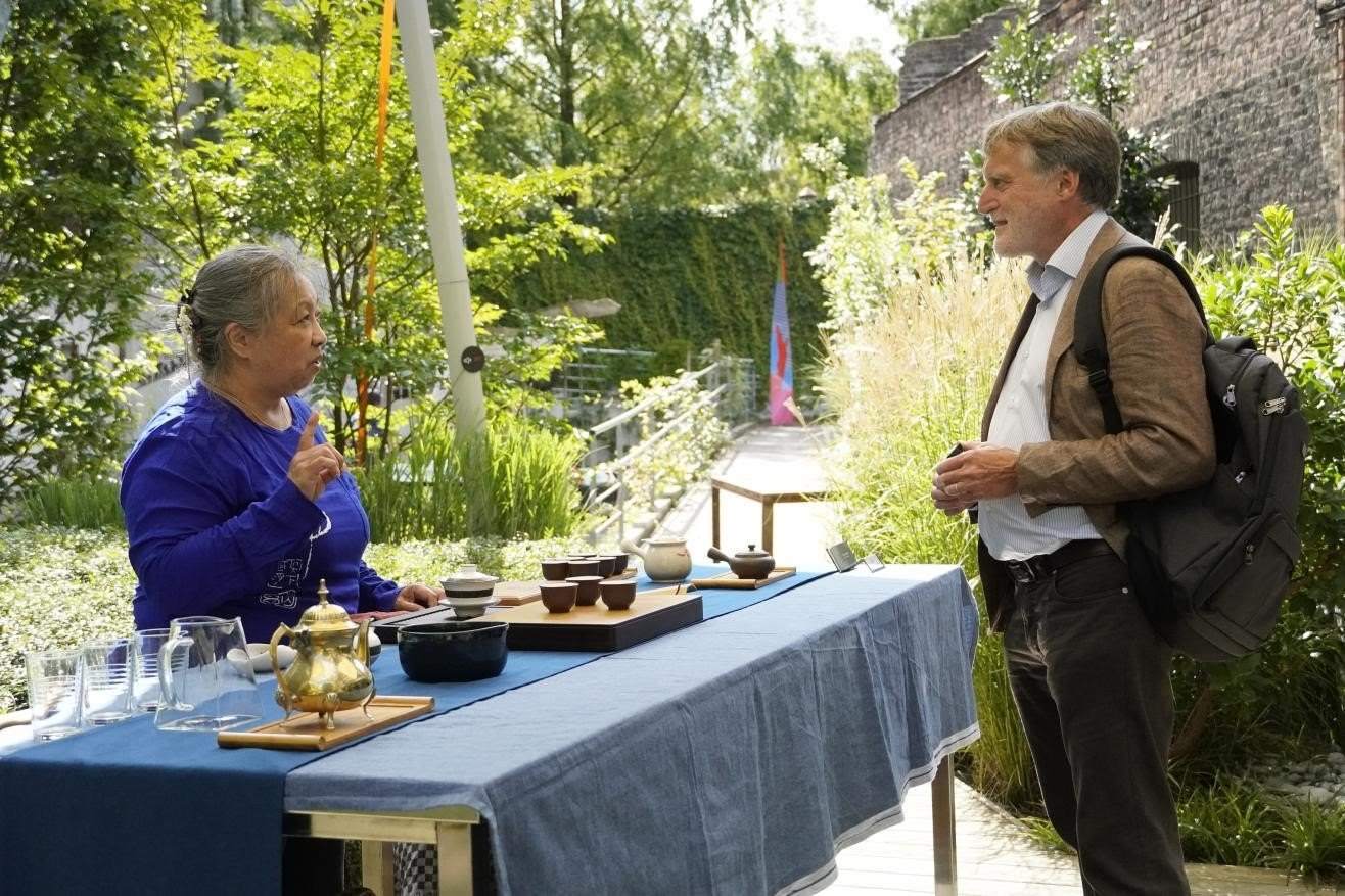 在博物館的戶外花園來賓品味中國茶藝。比利時維他命文化傳媒供圖
