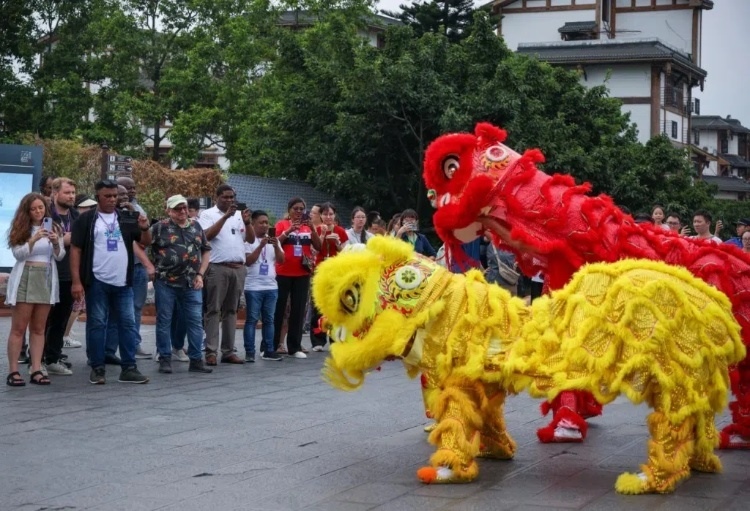 2024“一帶一路”媒體合作論壇聯(lián)合采訪調(diào)研行成員在樂山蘇稽古鎮(zhèn)觀看非遺舞獅表演。本報記者 伊霄攝