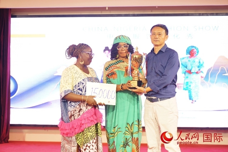 中國(guó)駐尼日利亞使館文化參贊兼中國(guó)文化中心主任李旭大（右）為最佳表現(xiàn)獎(jiǎng)?lì)C獎(jiǎng)（中）。人民網(wǎng)記者 姜宣攝