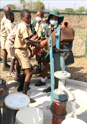 △2021年11月，在津巴布韋南馬塔貝萊蘭省省會(huì)關(guān)達(dá)的塞農(nóng)多小學(xué)，學(xué)生從中國援建水井里打水。