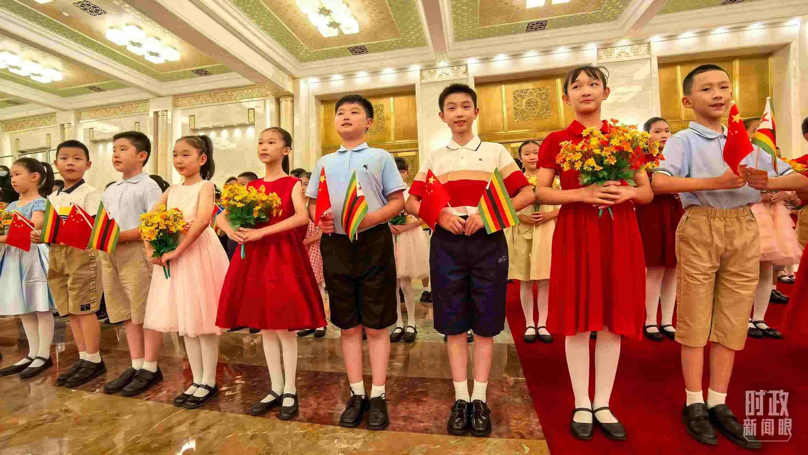 △現(xiàn)場歡迎津巴布韋總統(tǒng)訪華的青少年。（總臺(tái)央視記者鐘銳拍攝）