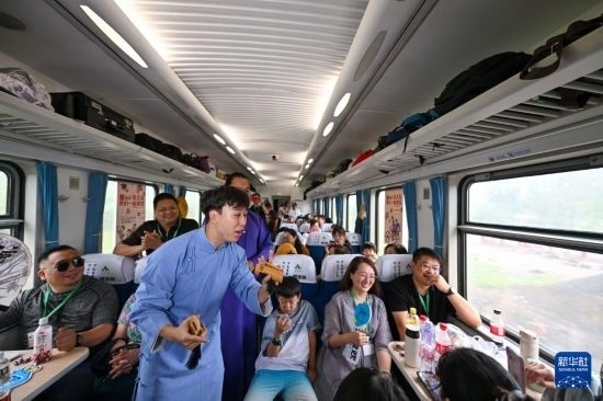 9月7日，相聲演員在S910列車上為旅客表演快板。