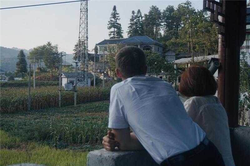 望得見山，看得見水，記得住鄉(xiāng)愁。每個人心中都有一個屬于自己的“花茂村”，在這方心田，走遍千山萬水，鄉(xiāng)音未改鬢毛衰。吉爾吉斯斯坦《比什凱克晚報》第一副總編輯妮娜·尼奇博洛娃與《中國與俄羅斯》雜志社社長奧列格·別列日內赫攝在花茂村民居屋檐下并肩佇立，眺望山水，尋覓鄉(xiāng)愁。（李光裕攝）