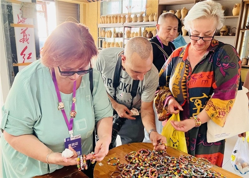 歐亞媒體考察團成員在母氏陶藝館內挑花了眼，色彩絢麗、質地均勻的陶藝手串讓他們愛不釋手?！斑@里的東西都太實惠了！”塔吉克斯坦《索格特真理報》政論部主任娜塔利婭·多羅費耶娃說?；宓奶厣a品物美價廉，讓考察團成員為家人好友買到了心儀的禮物，也為此次以四川成都為起點，路經南充、廣安至貴州遵義的考察行程畫上了圓滿句號。（張亞欣攝）