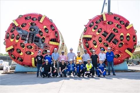 中外員工在盾構(gòu)機(jī)前合影。中國電建供圖